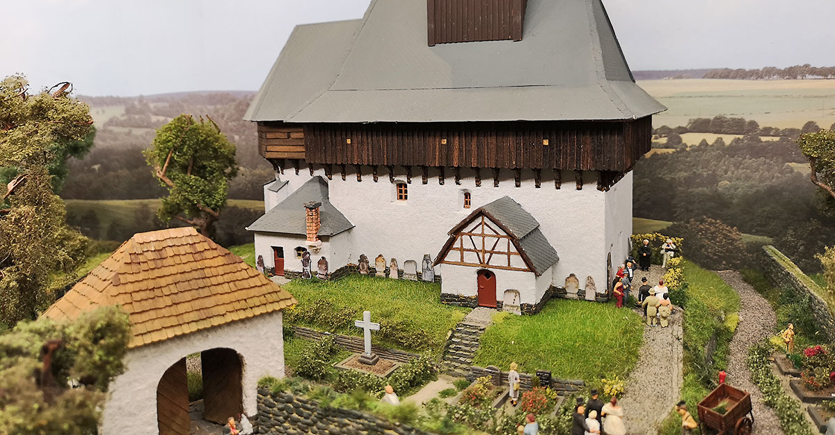 Landschaft mit Kirche und Friedhof